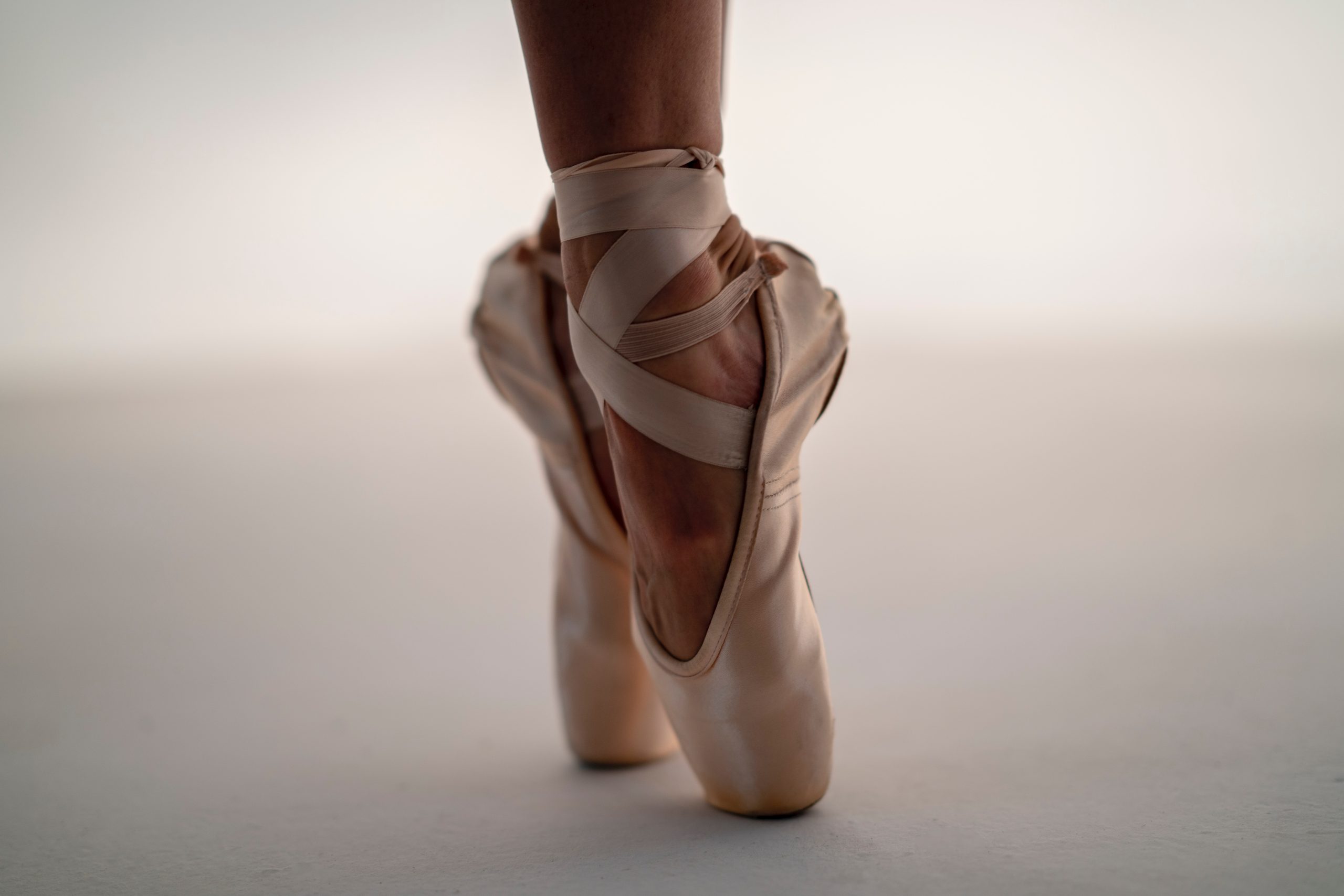 Puntas de ballet en posición sobre el suelo de la sala